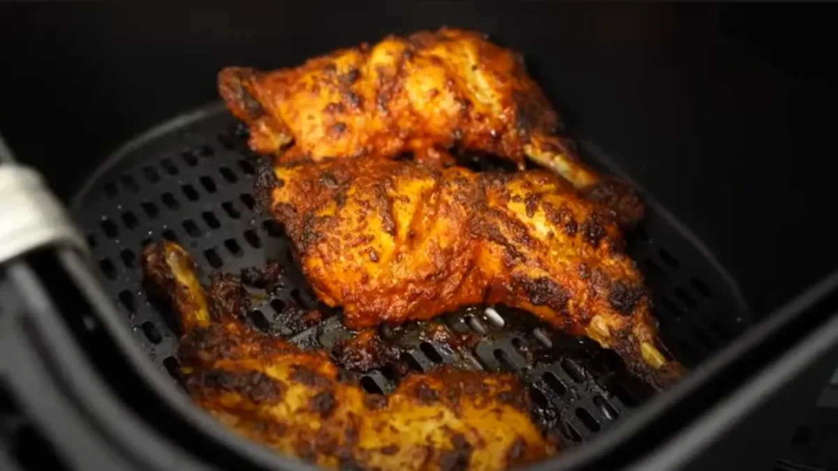 Juicy air fryer thighs with crispy, golden-brown skin, seasoned to perfection and served with herbs or sides