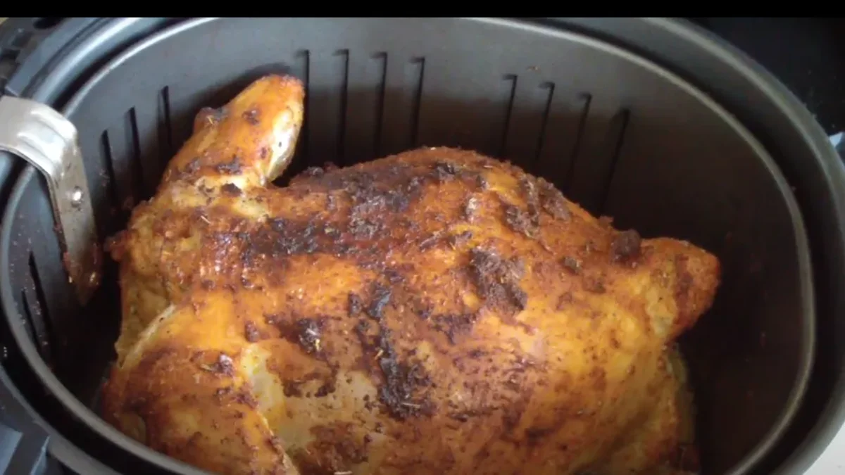 Perfectly roasted whole bird cooked in the air fryer, with crispy golden skin and juicy meat, served on a platter with fresh herbs.