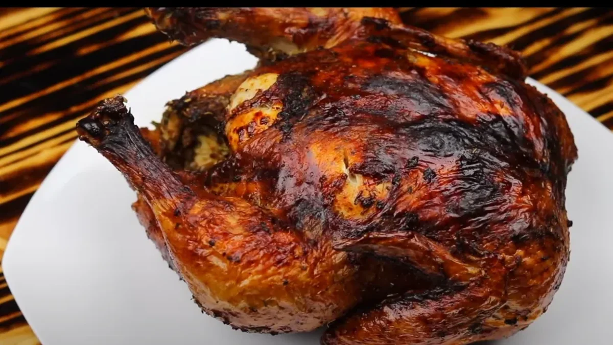 A golden-brown air fryer whole chicken on a serving platter, fresh out of the air fryer