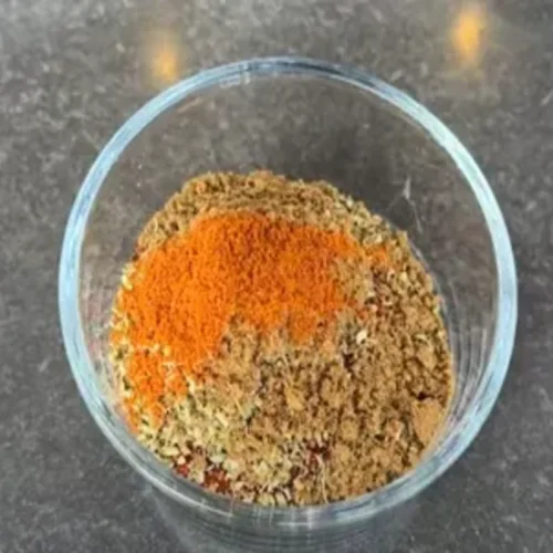 A variety of spices like paprika, salt, and garlic powder, laid out to create a homemade chicken rub